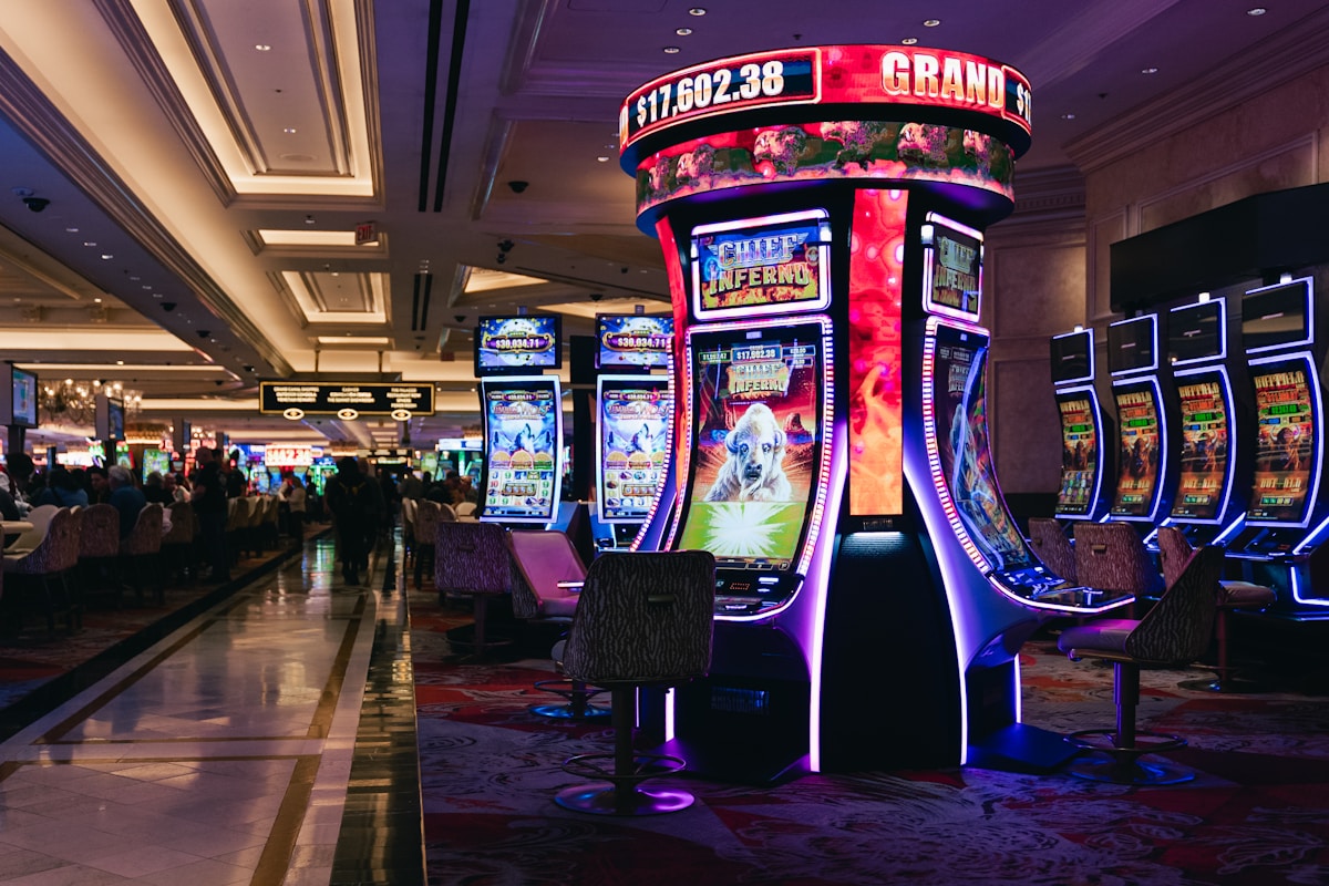 Illuminated slot machines along a warmly lit casino resort floor