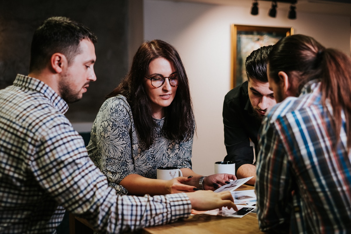 A hotel management team reviewing documents together at a table - the working session where an AI acceptable-use policy actually gets written