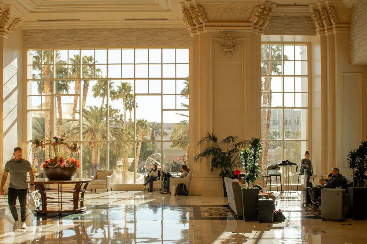 Guests spread across the lounge seating of a modern hotel lobby, the kind of occupancy pattern computer vision measures and management currently estimates