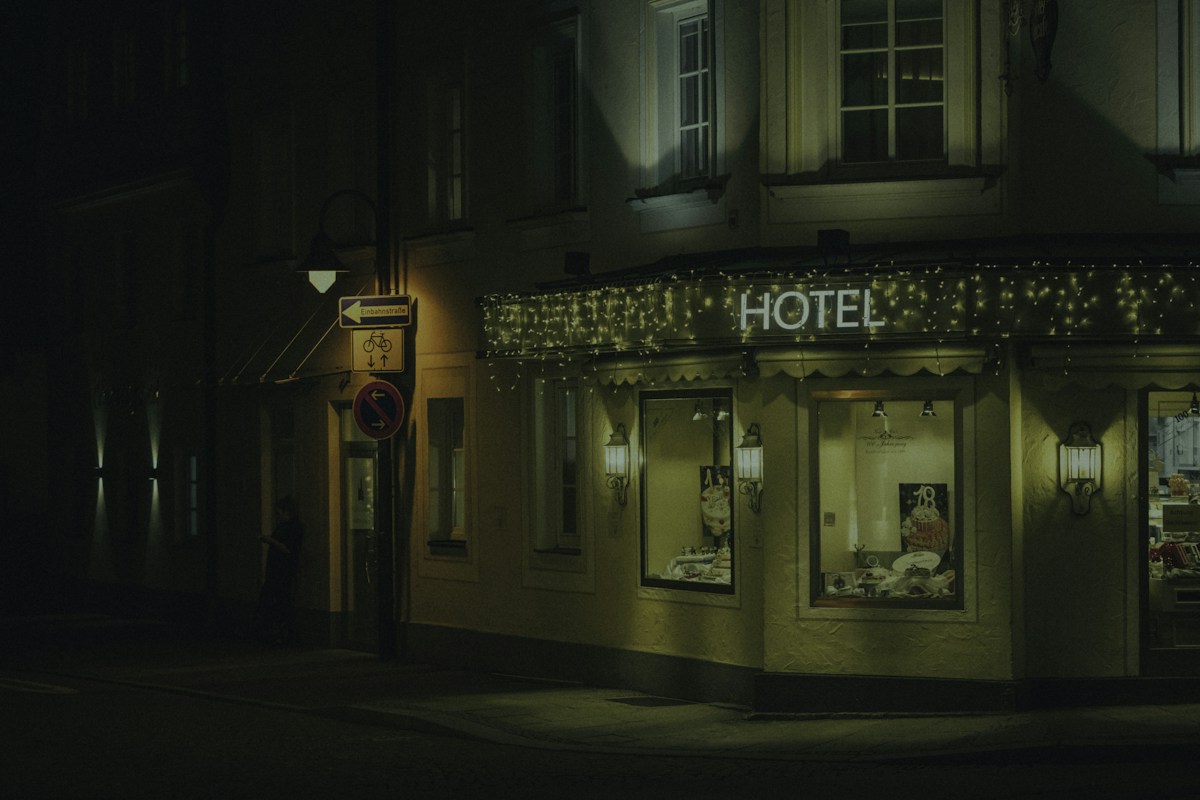 A hotel glowing on a street corner at night, the visibility that metasearch bidding ultimately pays to win